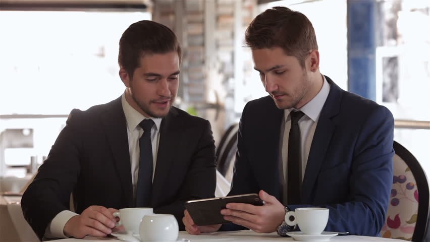 two business men looking on the screen of the tablet